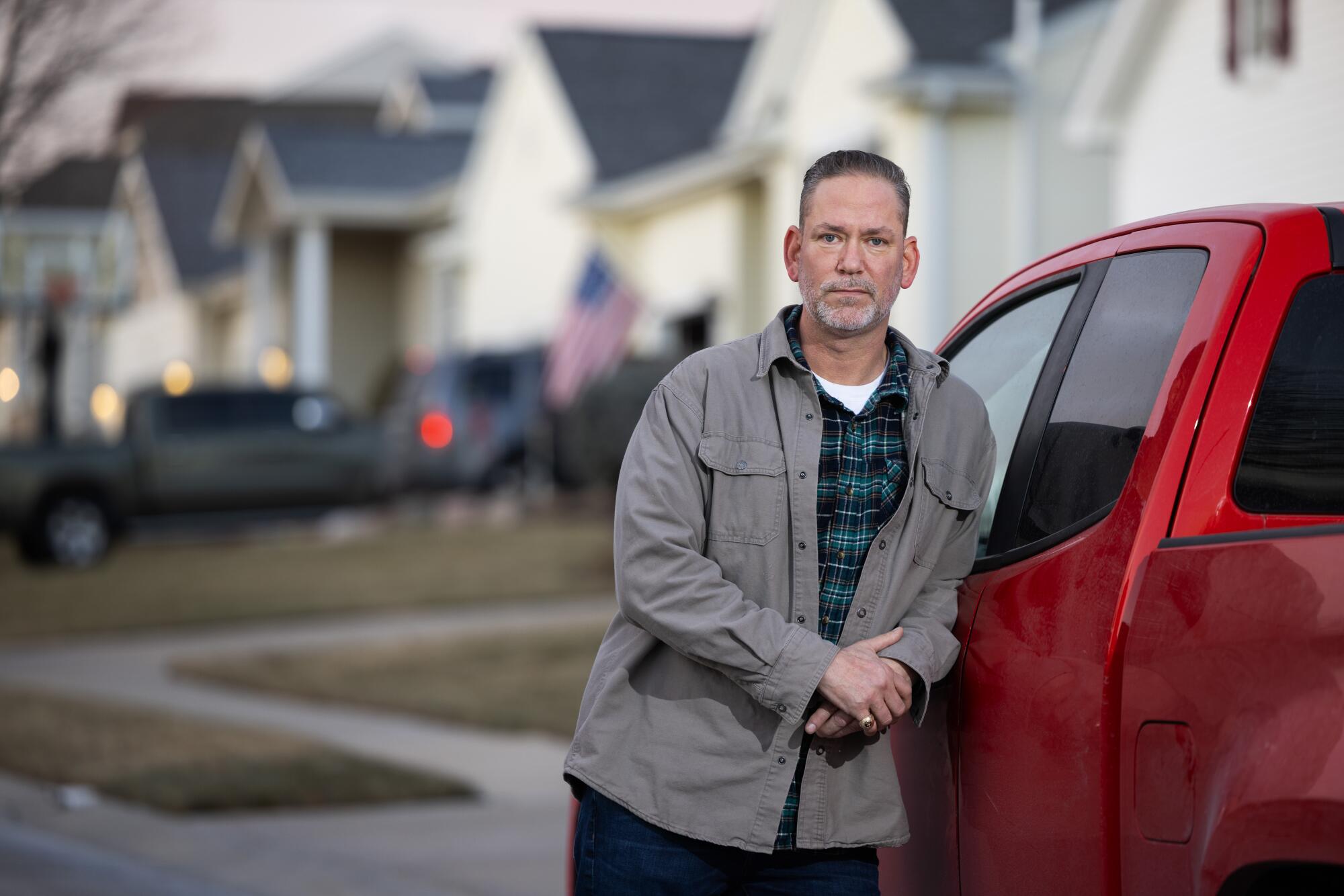 Dan Osborn leans against a red truck.