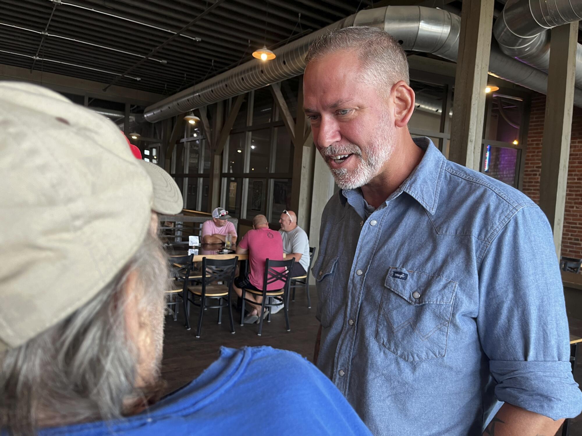 Dan Osborn chats with patrons of a brewery in Beatrice, Neb.