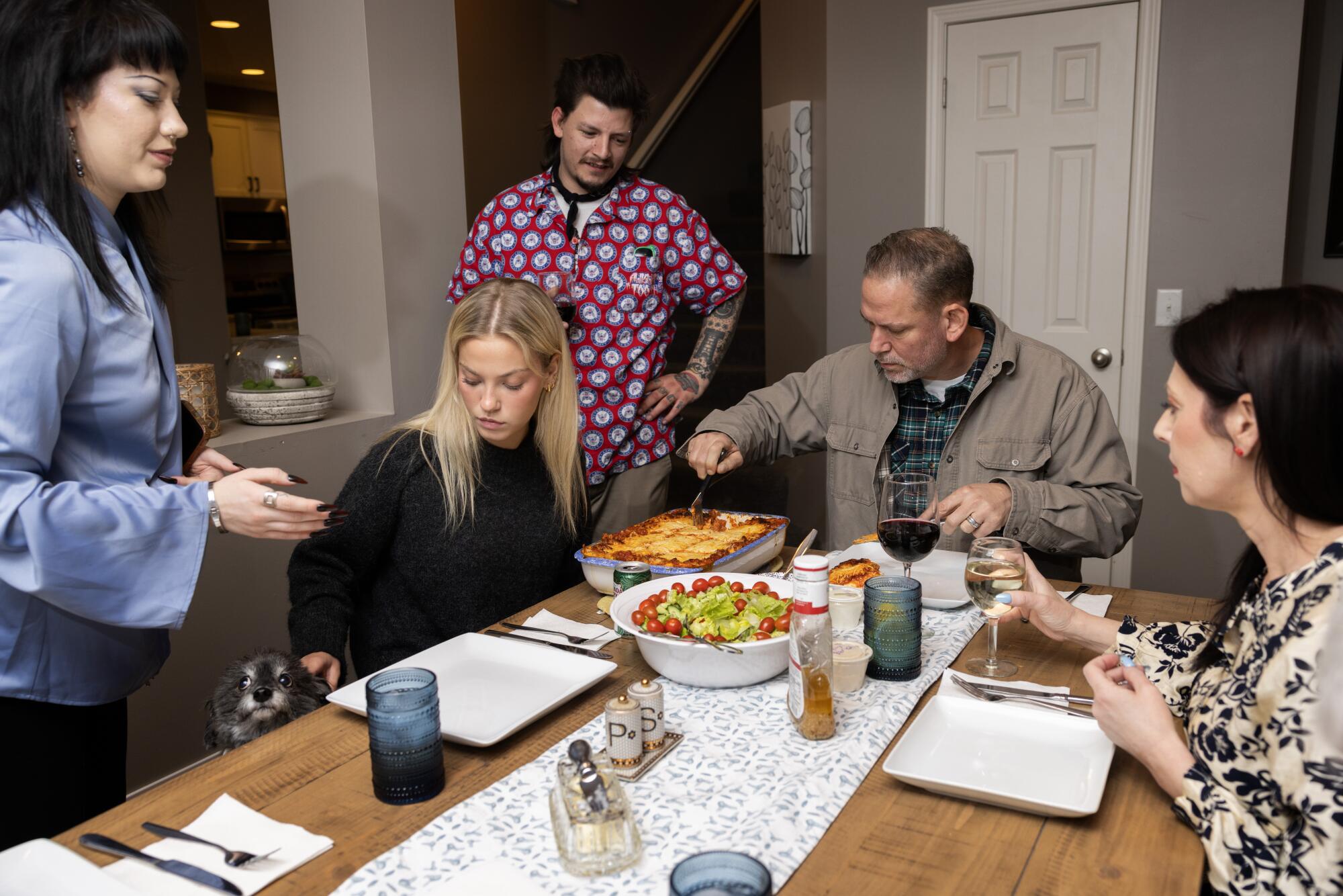 A family gathers at the dinner table.