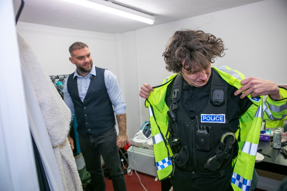 A person putting on a police uniform.