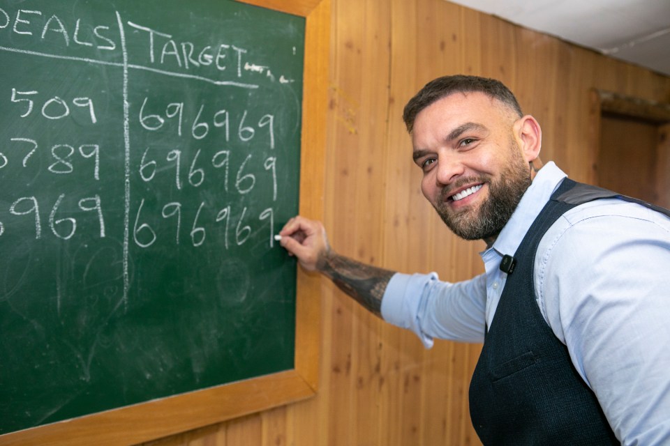 Man writing numbers on a chalkboard.