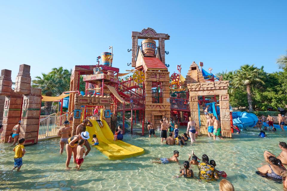 Children playing in a water park playground.