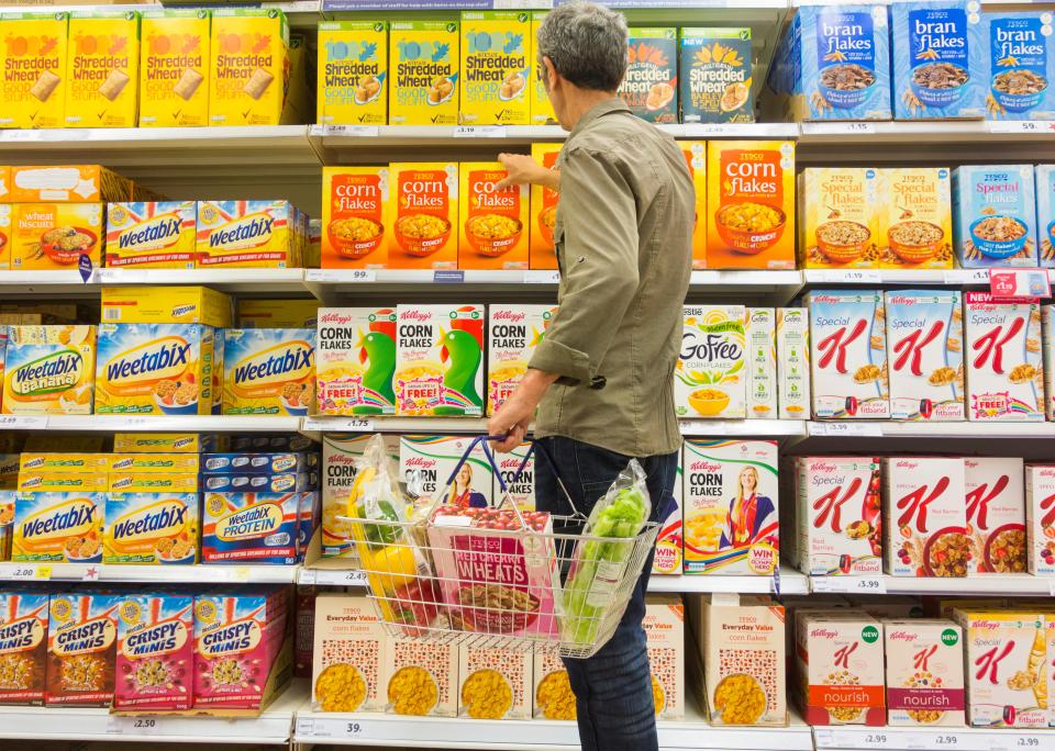 Man shopping for breakfast cereal in a supermarket.