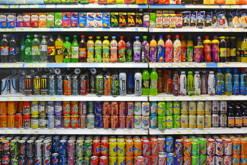 Shelves of soft drinks in a convenience store.