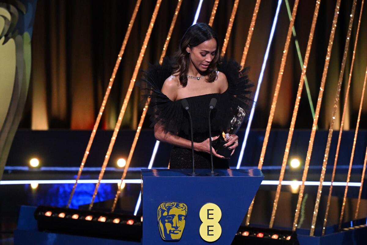 A smiling woman accepts an acting honor.