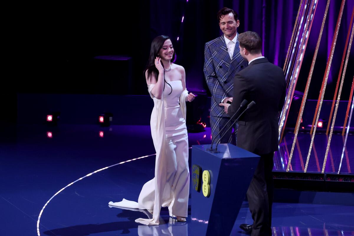 A smiling woman receives an award.