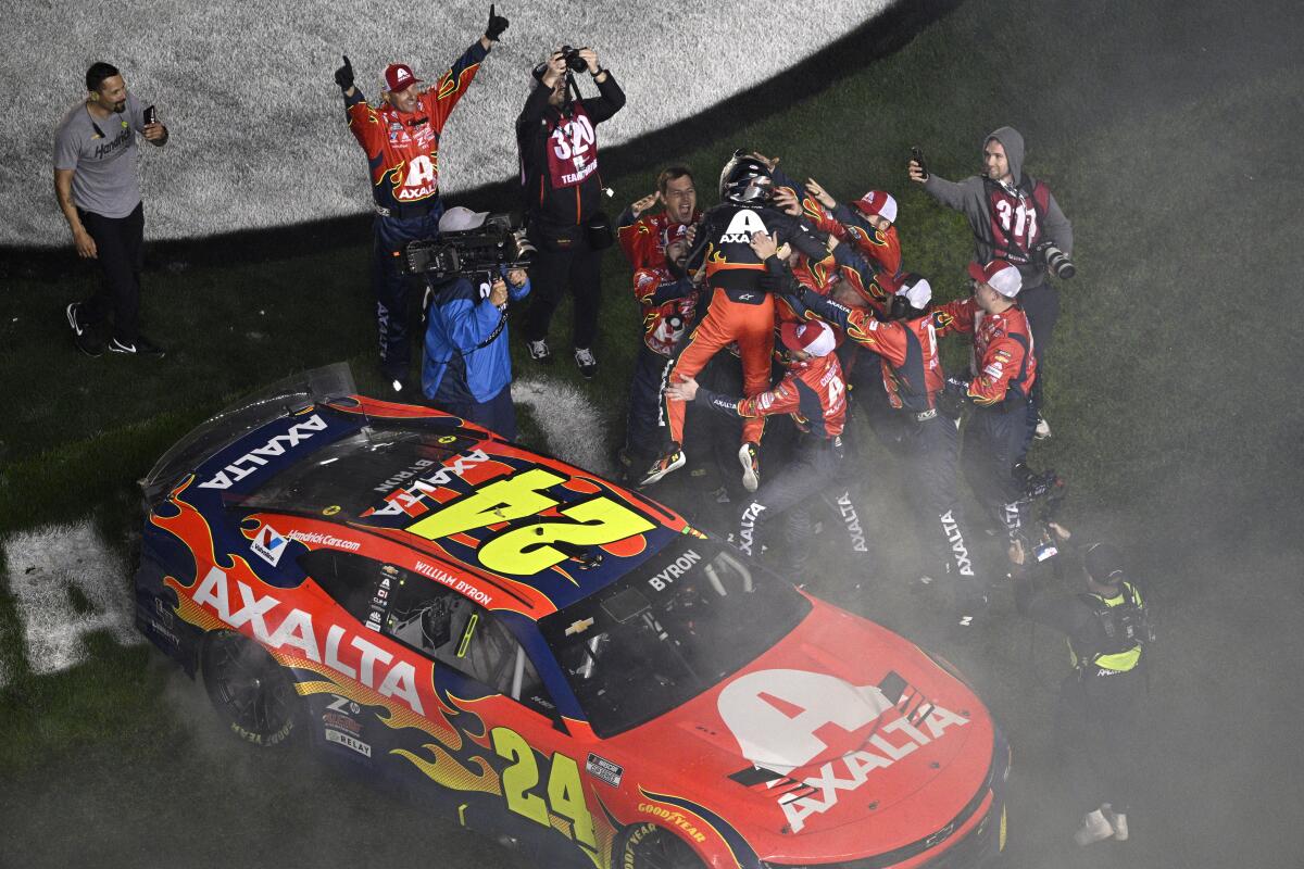 William Byron leaps from the top of his car into the arms of crew members after winning the Daytona 500 on Sunday night.