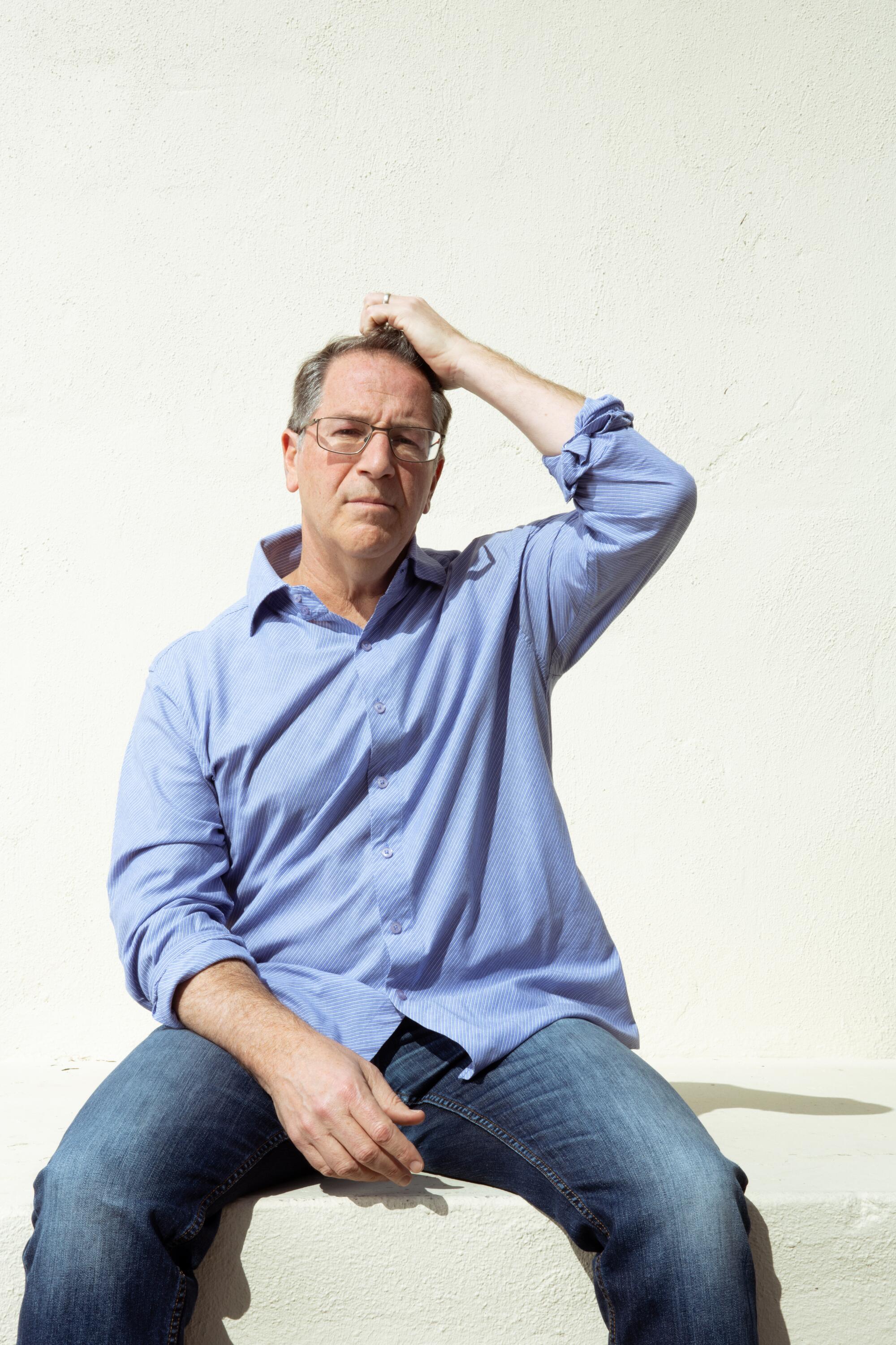 A smiling Aaron Korsh in a blue button-down shirt