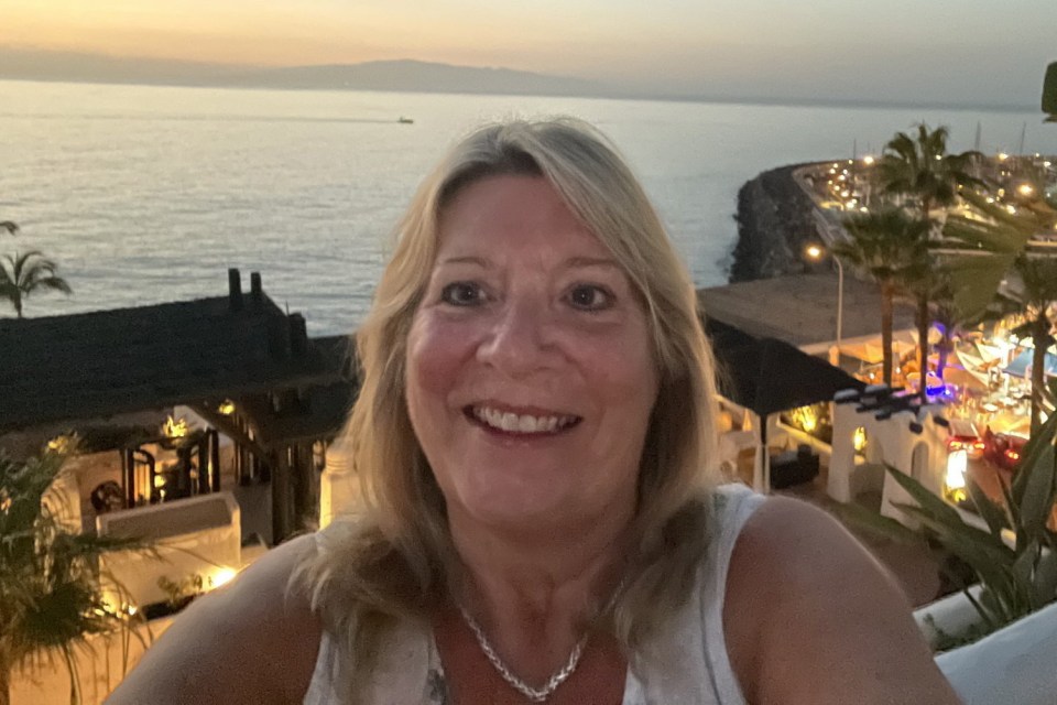 Selfie of Debbie Wearing, a stalking victim, overlooking a coastal town at sunset.