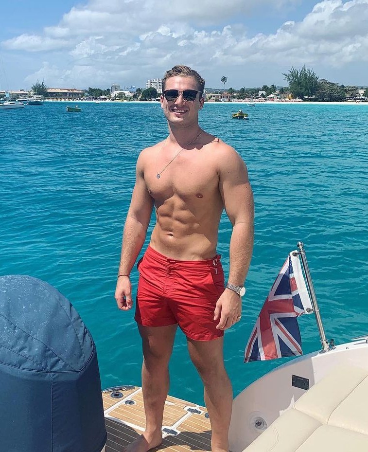 Man in red swim trunks on a boat.