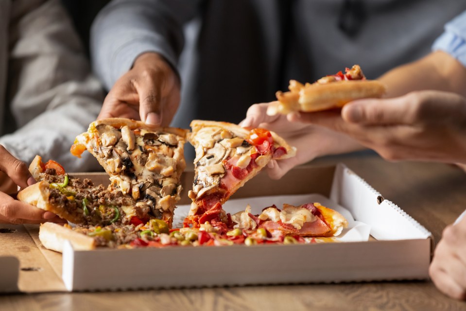 Close-up of multiethnic young people sharing pizza.