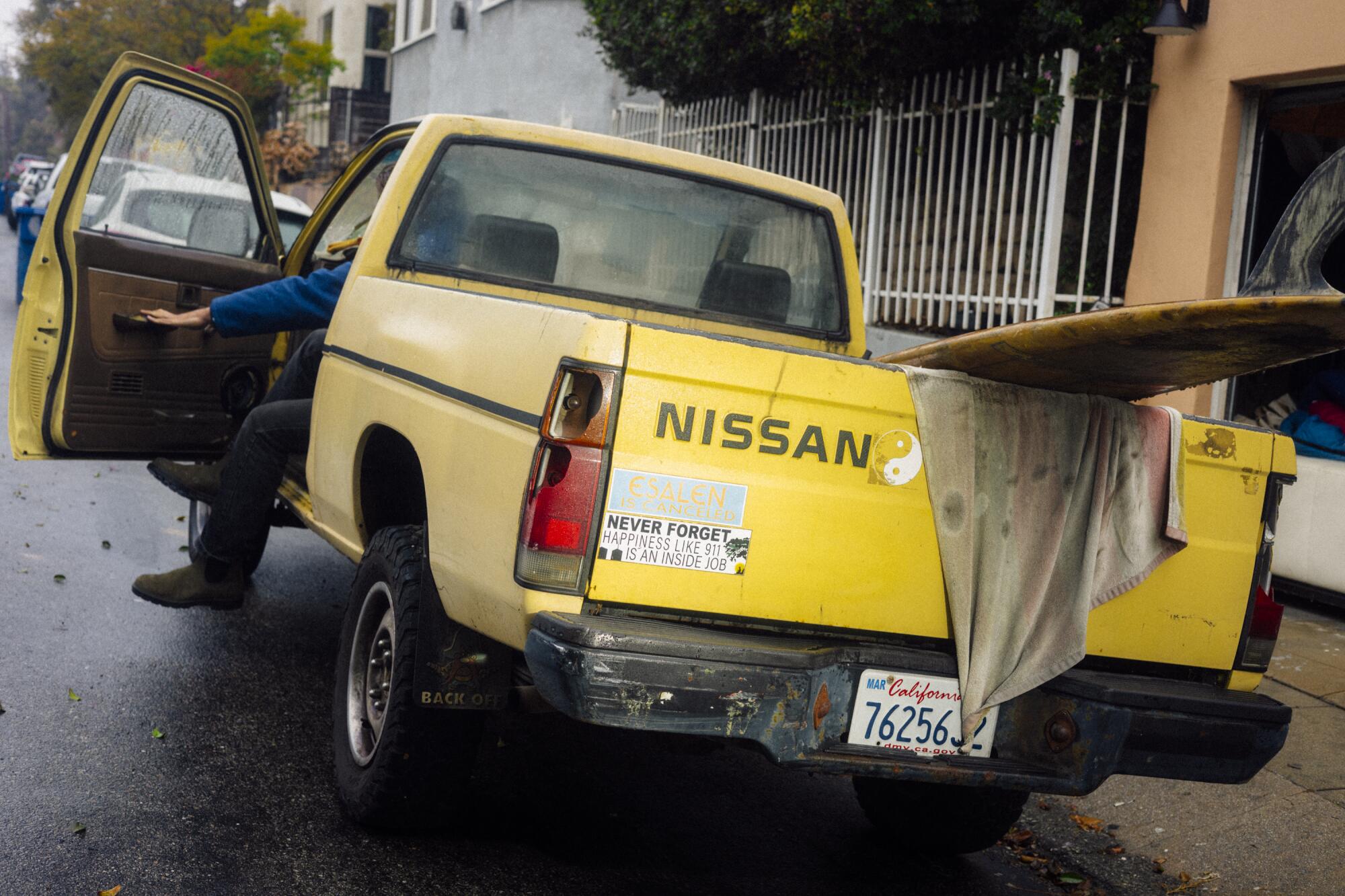 A pick up truck with a couple of bumper stickers on the back.