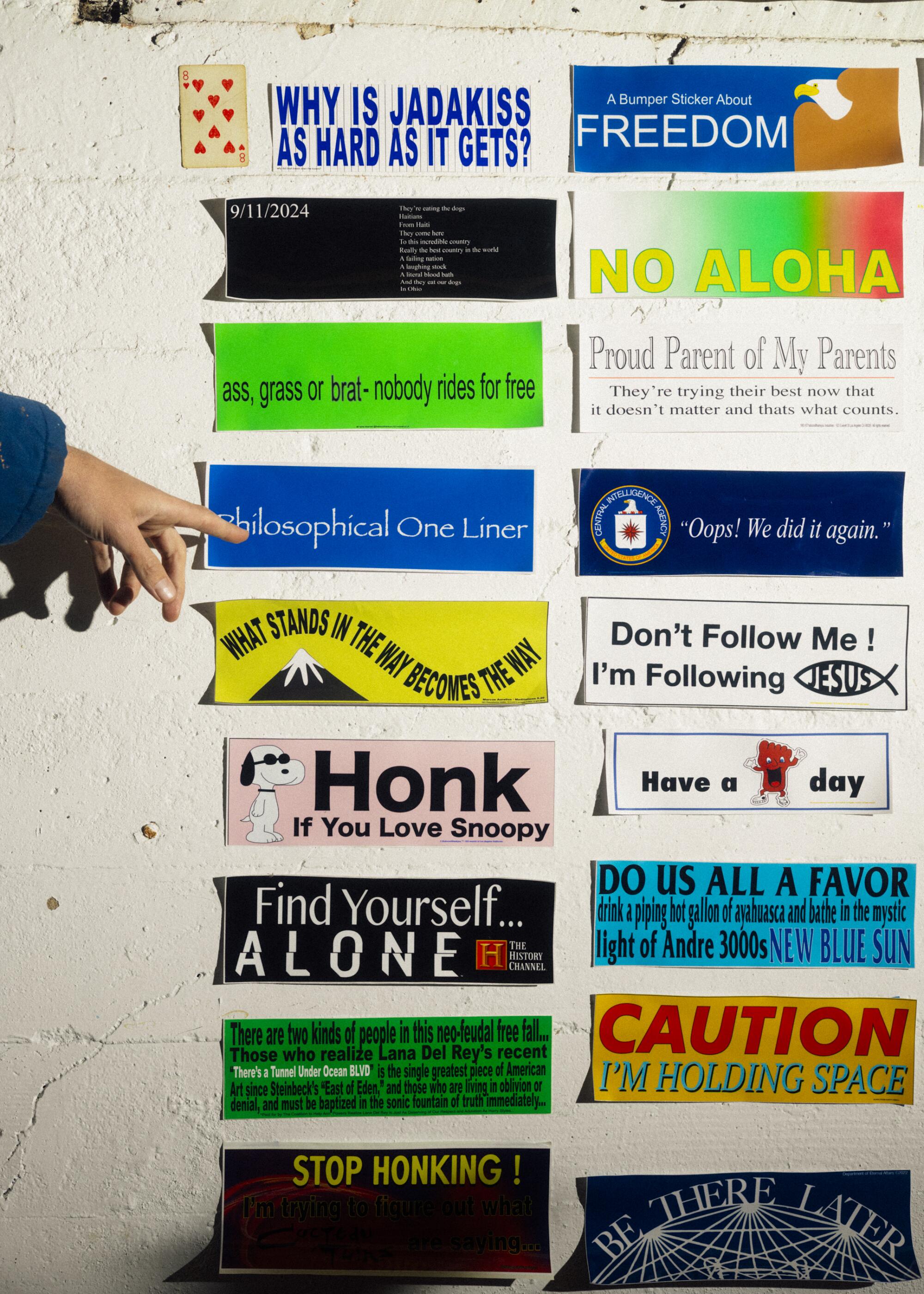 Bumper stickers lined up on a wall.