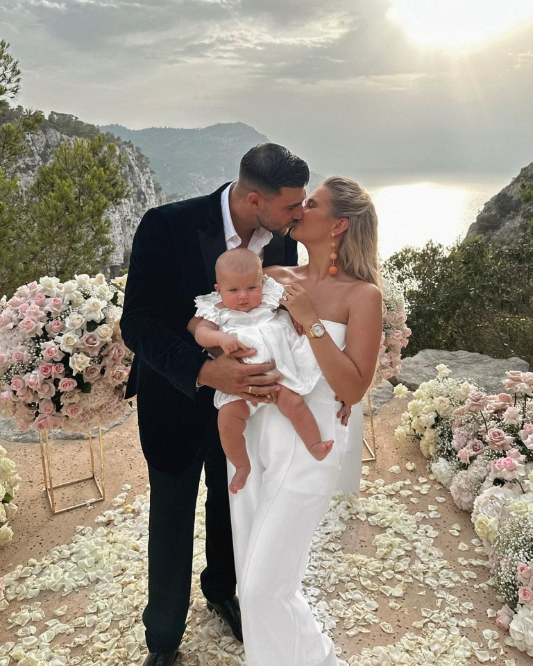 Molly Mae and Tommy Fury kissing with their baby.