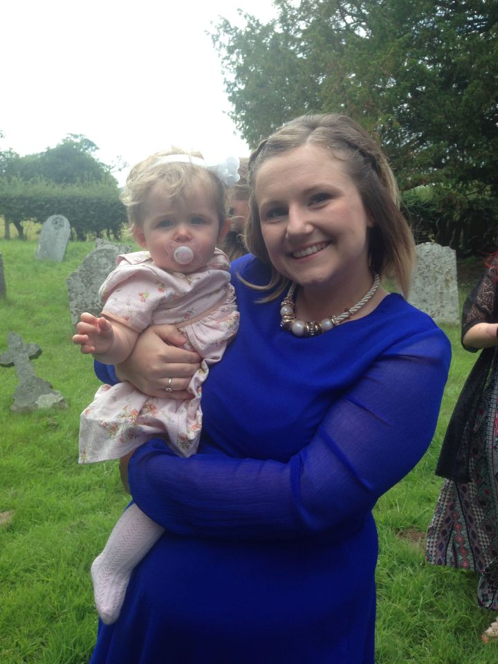 Woman in blue dress holding a baby.