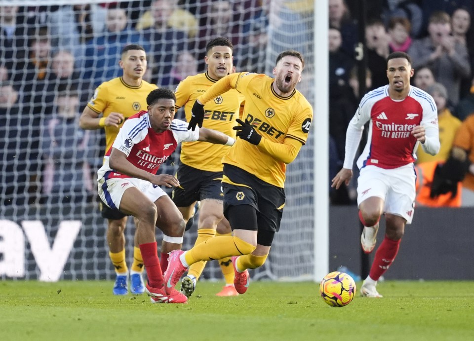 Arsenal's Myles Lewis-Skelly fouling a Wolverhampton Wanderers player.