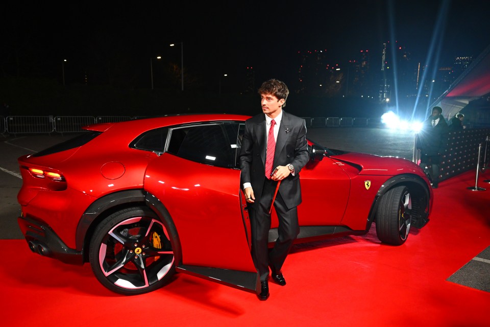 Charles Leclerc of Scuderia Ferrari exiting a red Ferrari.