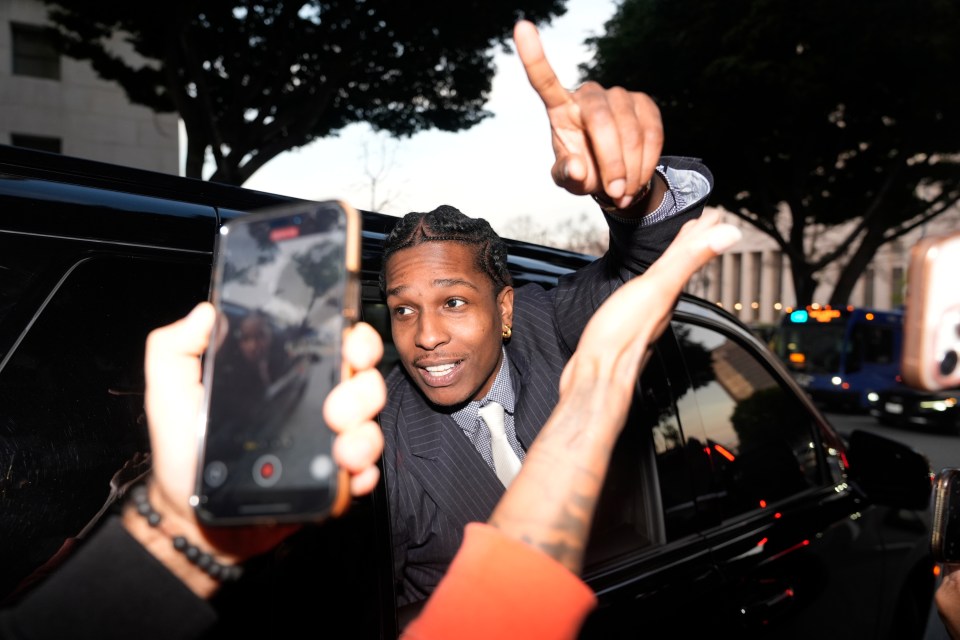 A$AP Rocky gestures from a car window to fans.