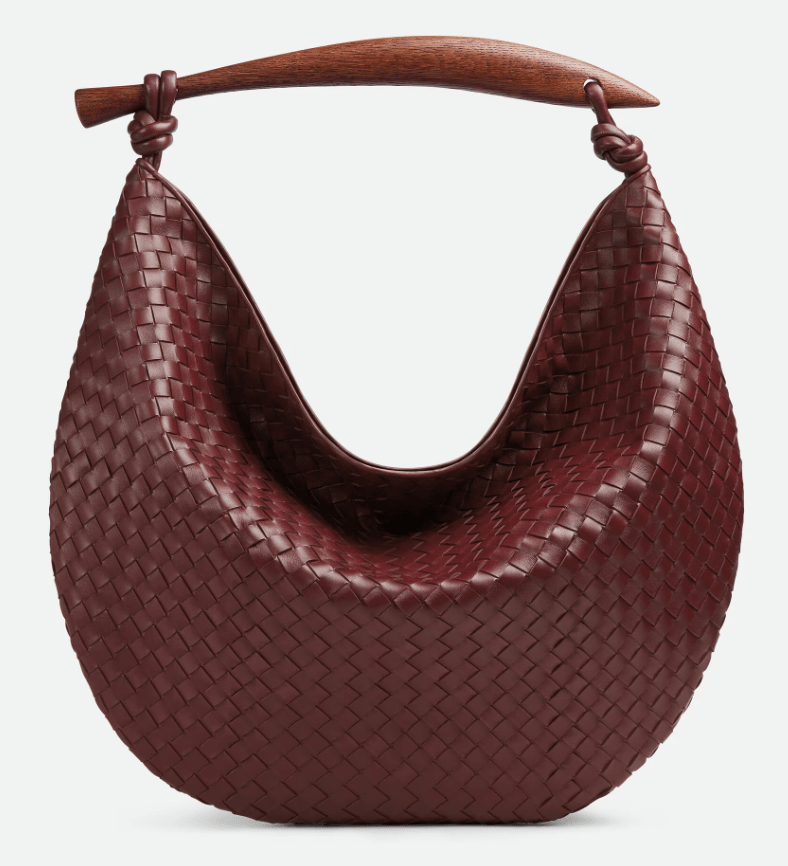 Burgundy woven leather handbag with wooden handle.