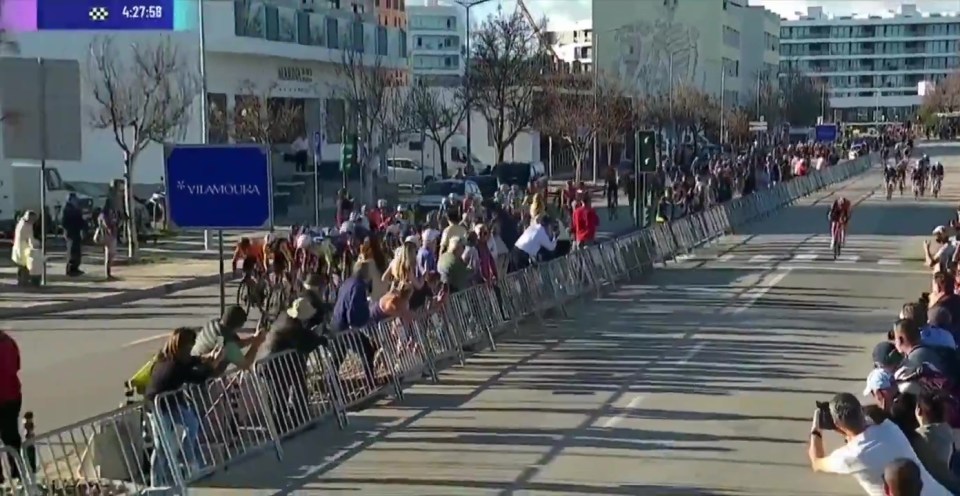 Cyclists racing, spectators lining the course.