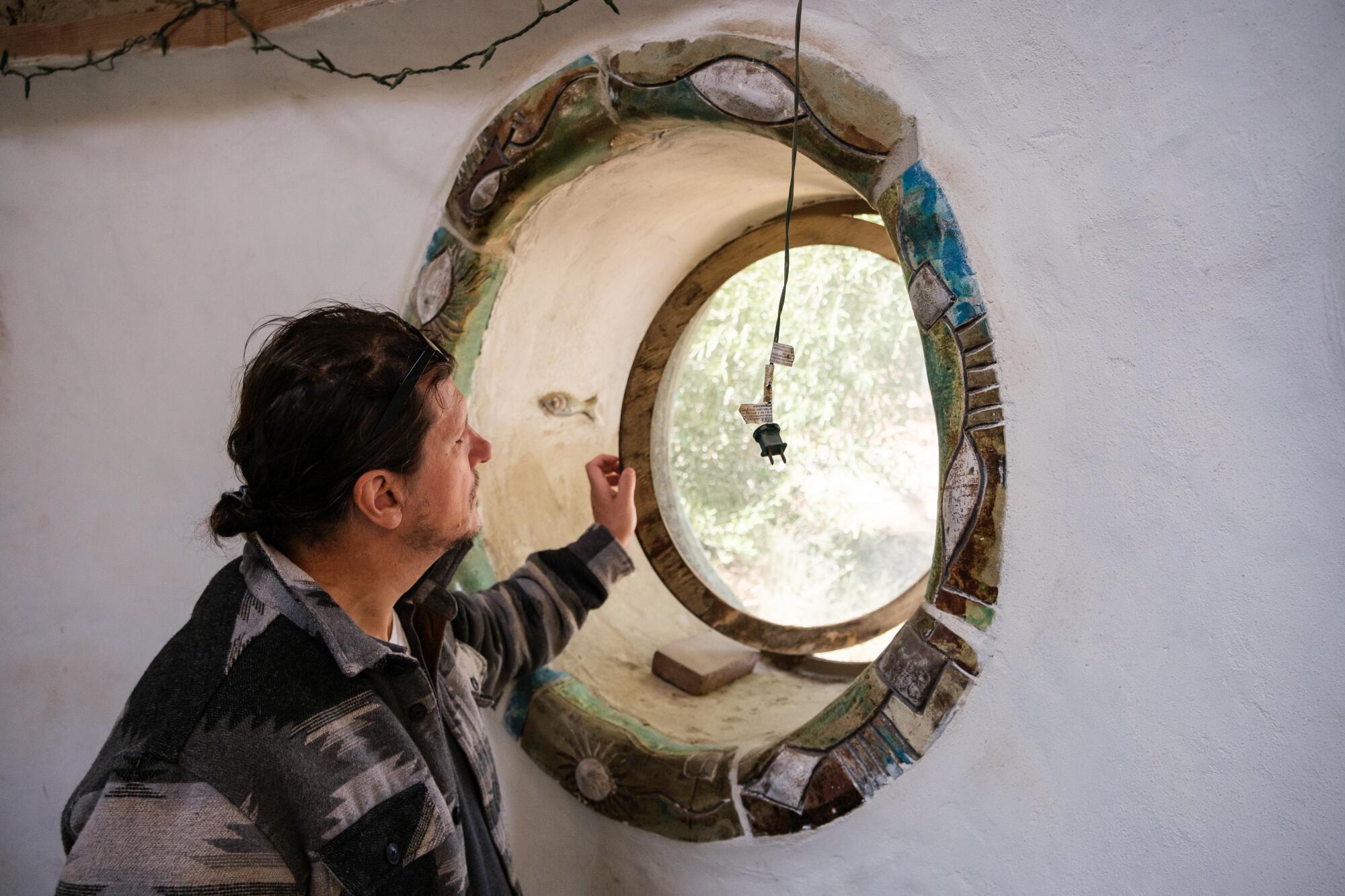 Andrew Martz examines a window. SuperAdobe homes are infinitely customizable.