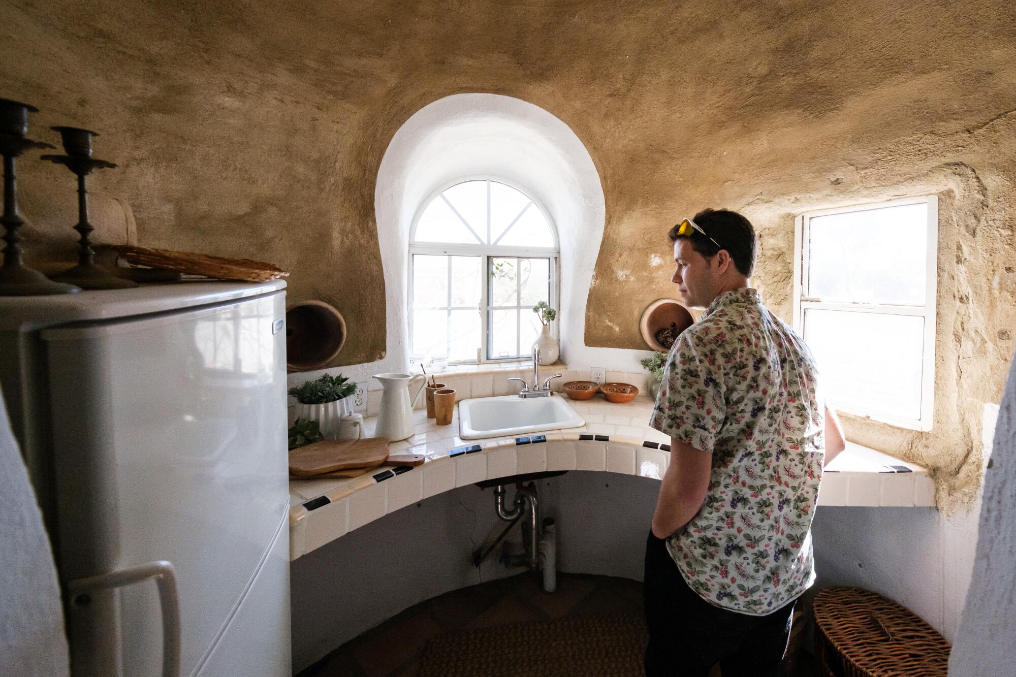 Justin Schachter examines a sink inside a SuperAdobe. Homes can be connected to any city’s electric grid and sewer line.