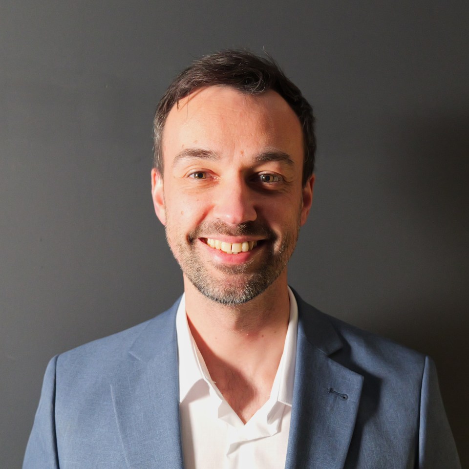 Portrait of a smiling man in a blue suit.