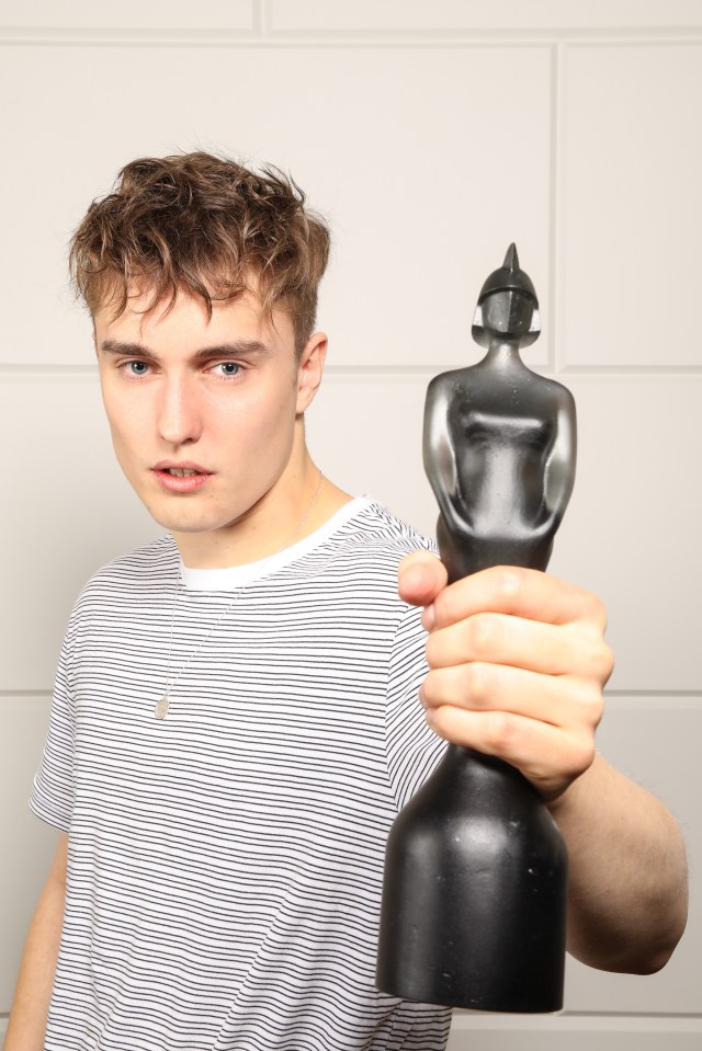 Sam Fender holding a Brit Award.