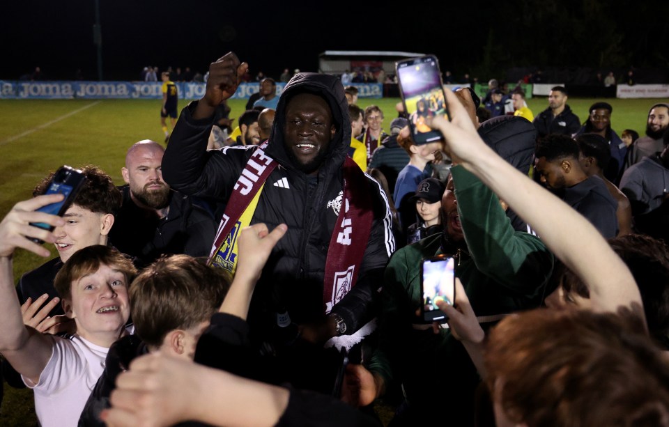 Stormzy celebrating with AFC Croydon Athletic players and fans after a soccer match.