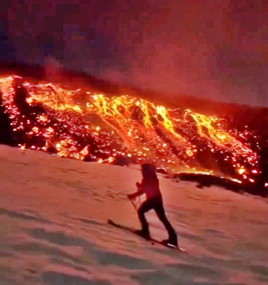 Skier skiing near an erupting volcano.