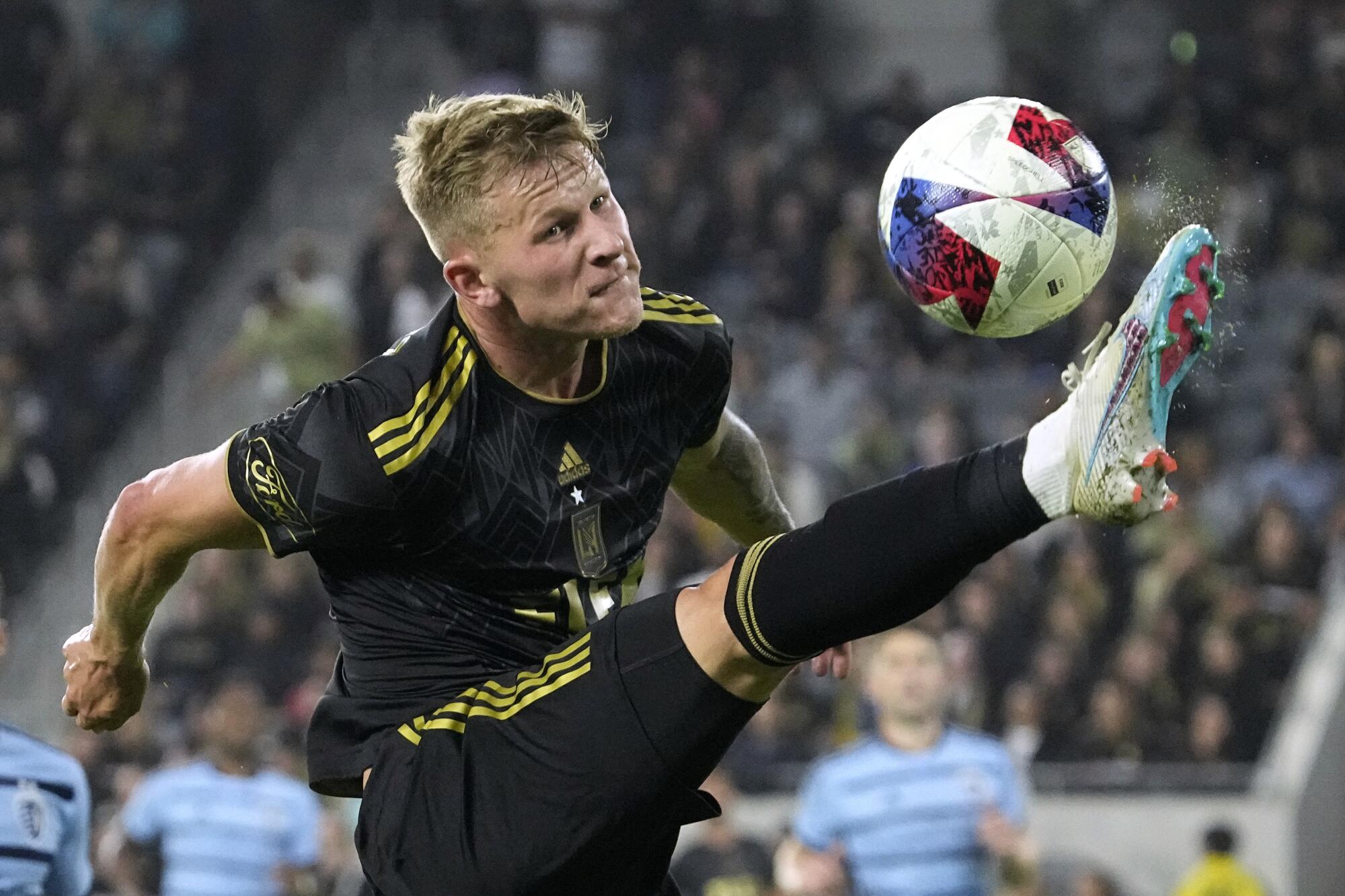 LAFC midfielder Mateusz Bogusz, right, kicks the ball during the second half.