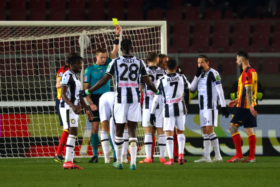 Referee showing a yellow card to a soccer player.