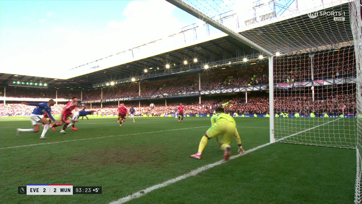 Soccer game in progress, goalkeeper diving to make a save.