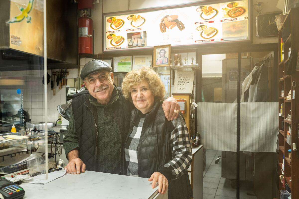 Harry Tashjian and Rebeka Tashjianhind the counter of a deli.