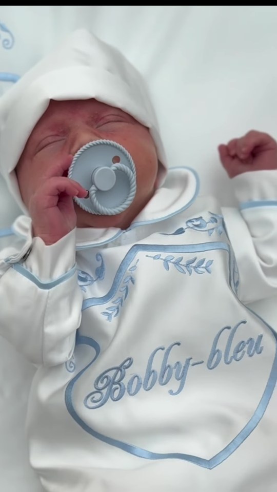 Newborn baby Bobby-Bleu in white outfit.