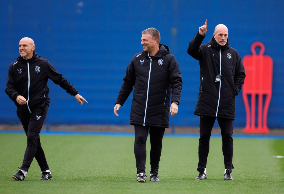 three men walking on a field with one pointing up