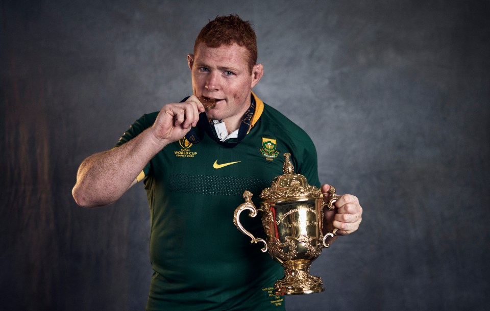 Steven Kitshoff of South Africa holding the Webb Ellis Cup and a medal.