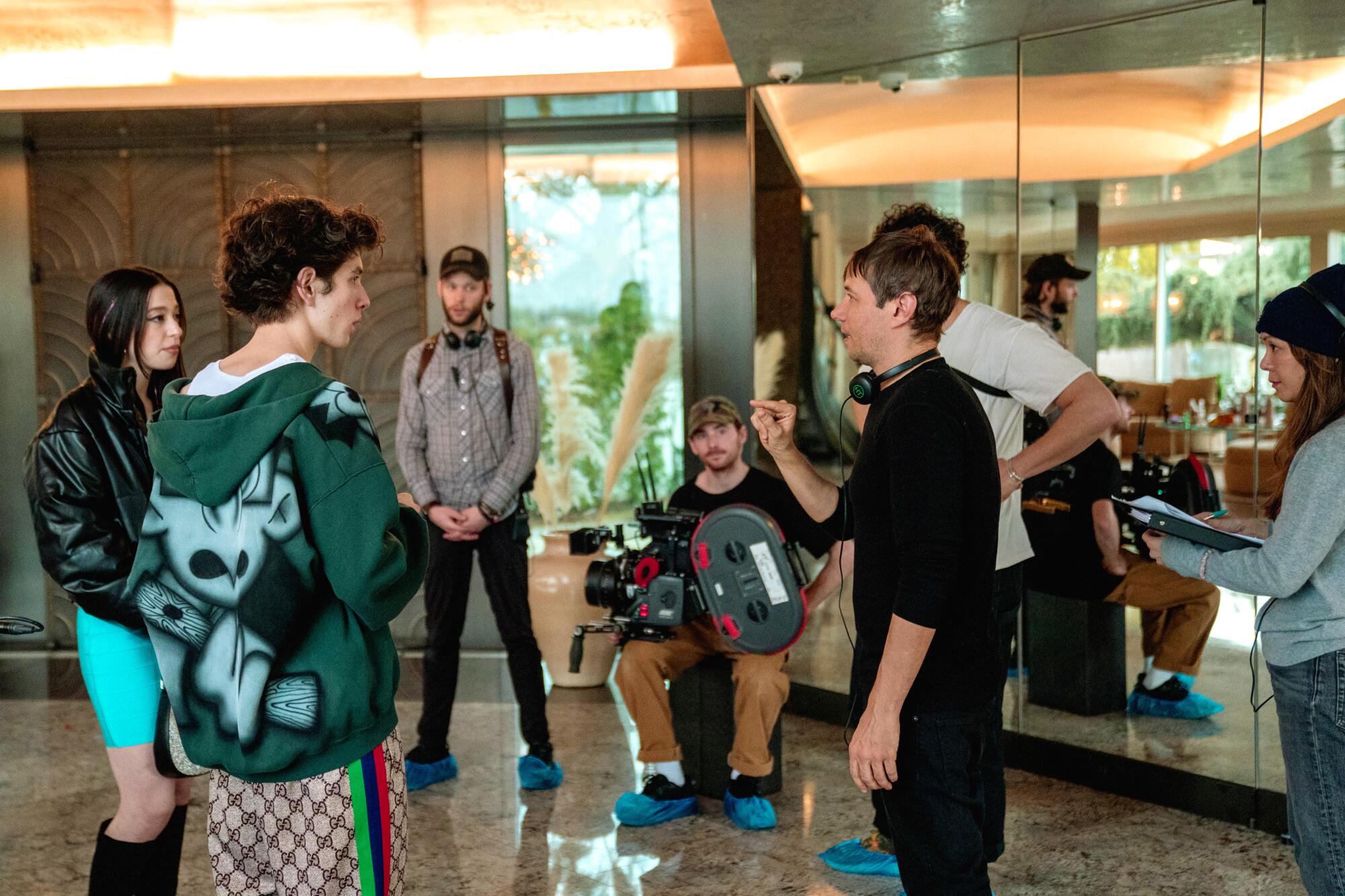 A director wearing headphones gives actors notes.