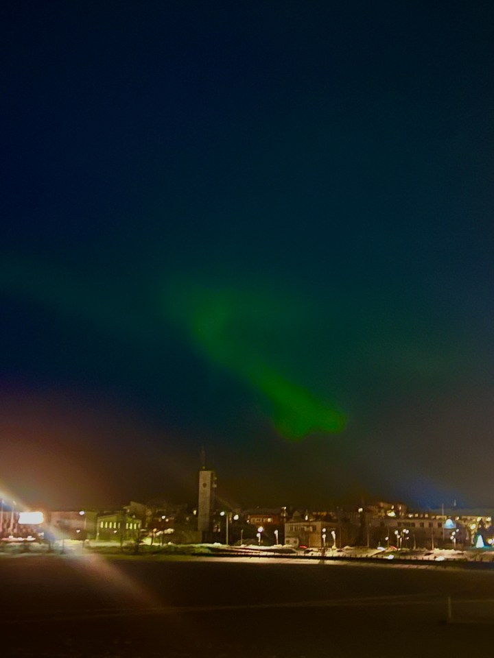 Northern lights over a town at night.