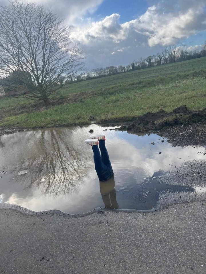 Fake legs in a large pothole.