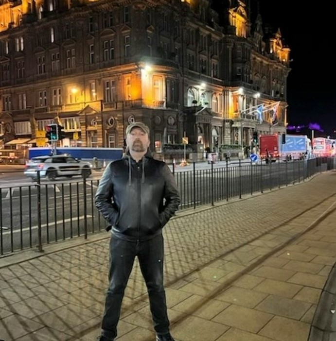 Paul Draper of Mansun standing outside a building at night.