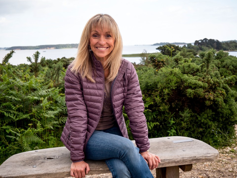 Michaela Strachan sitting on a bench outdoors.