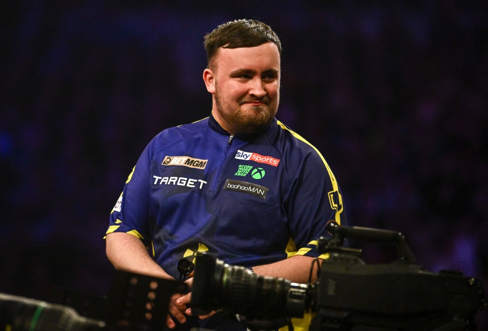 Luke Littler reacting during a darts match.