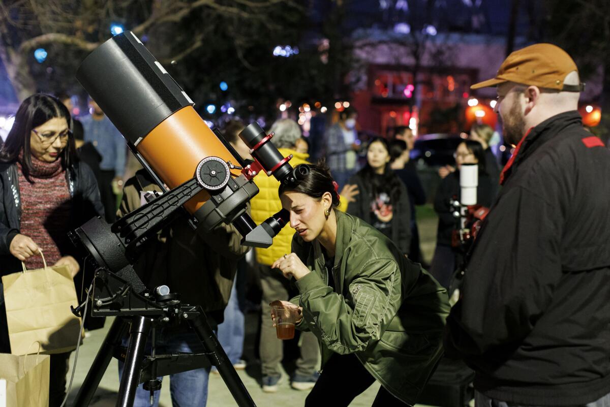 Nora Mae looks through a telescope at The Star Party