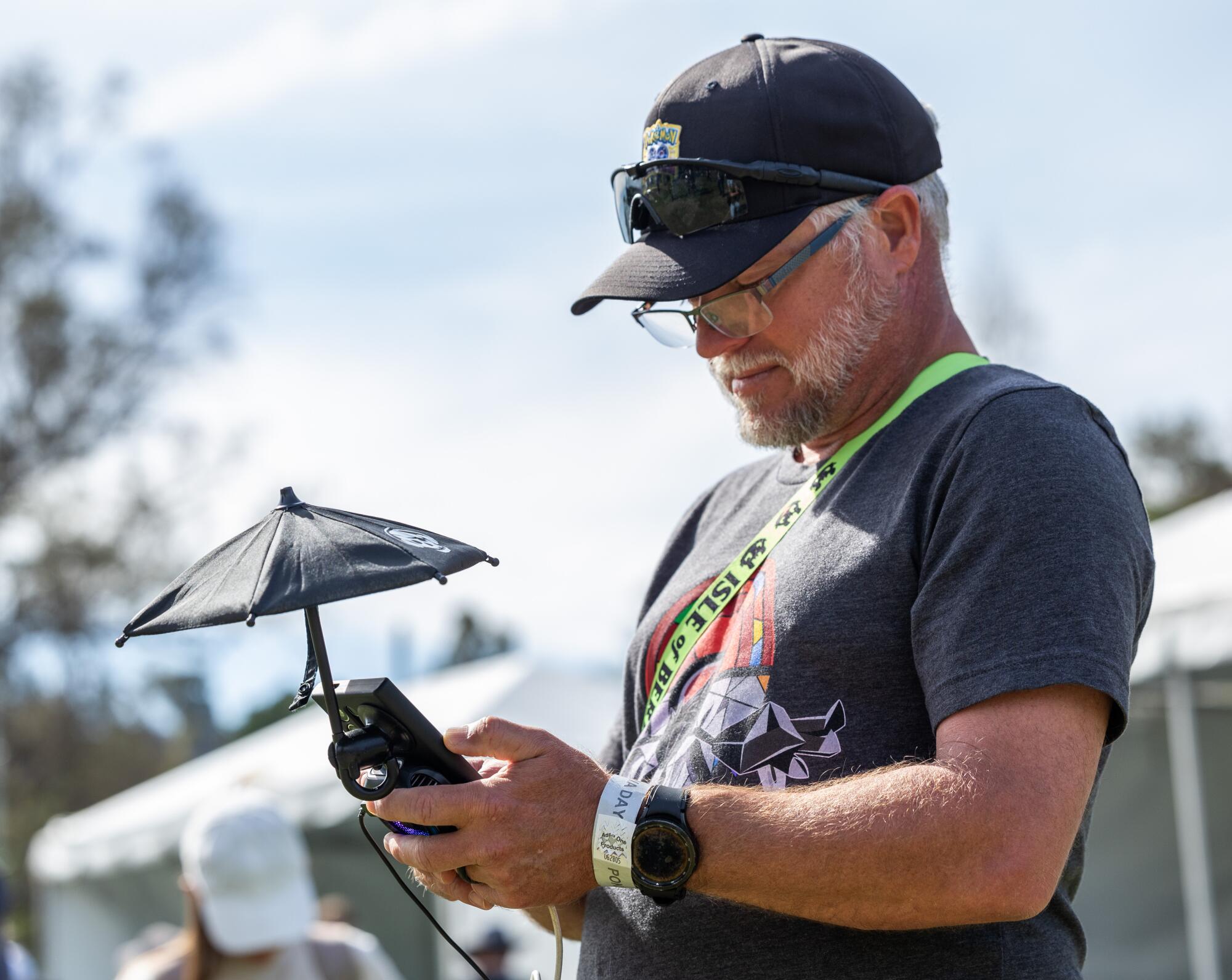 Mike Simmons of Florida uses a phone umbrella to better see his screen while catching Pokémon.