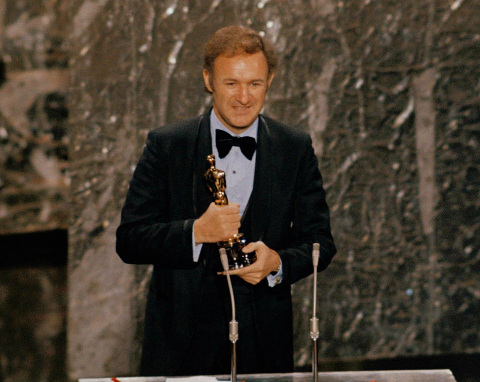 Man in tuxedo holding an Oscar.