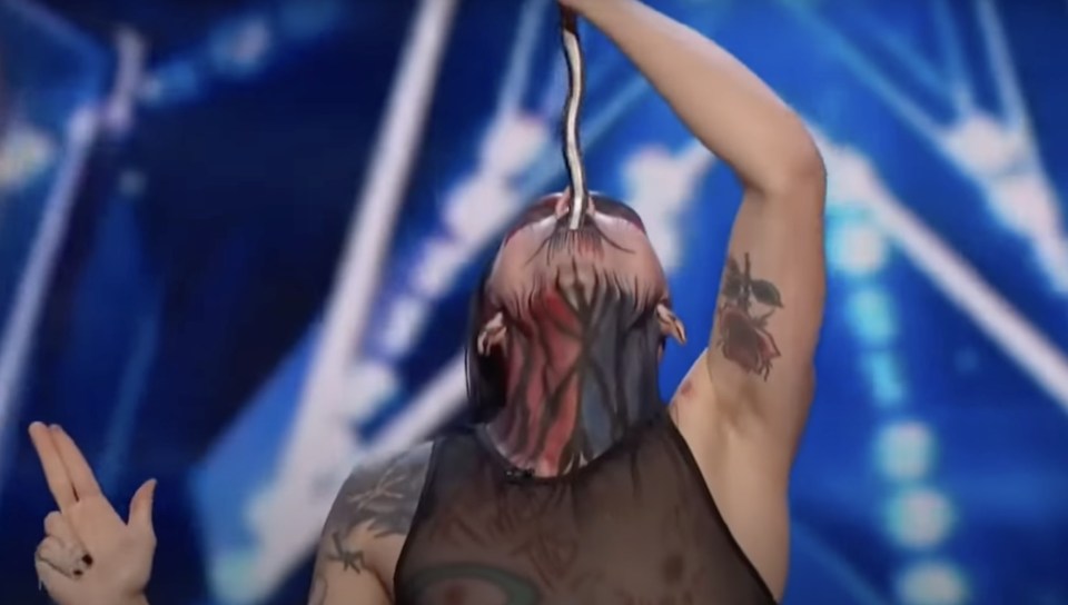 A performer with face paint swallowing a long, thin object on Britain's Got Talent.