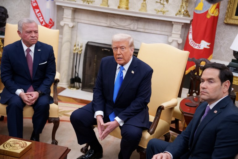 three men in suits sit in an ornate gold decorated room