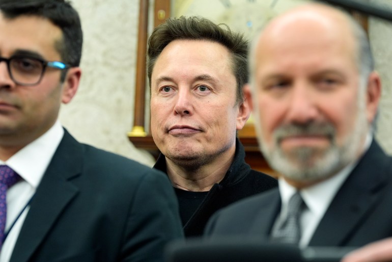 Elon Musk behind officials in the Oval Office.