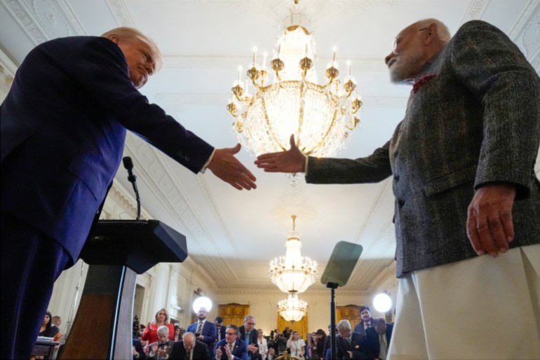 Donald Trump and Narendra Modi reach out at a White House press conference for a handshake